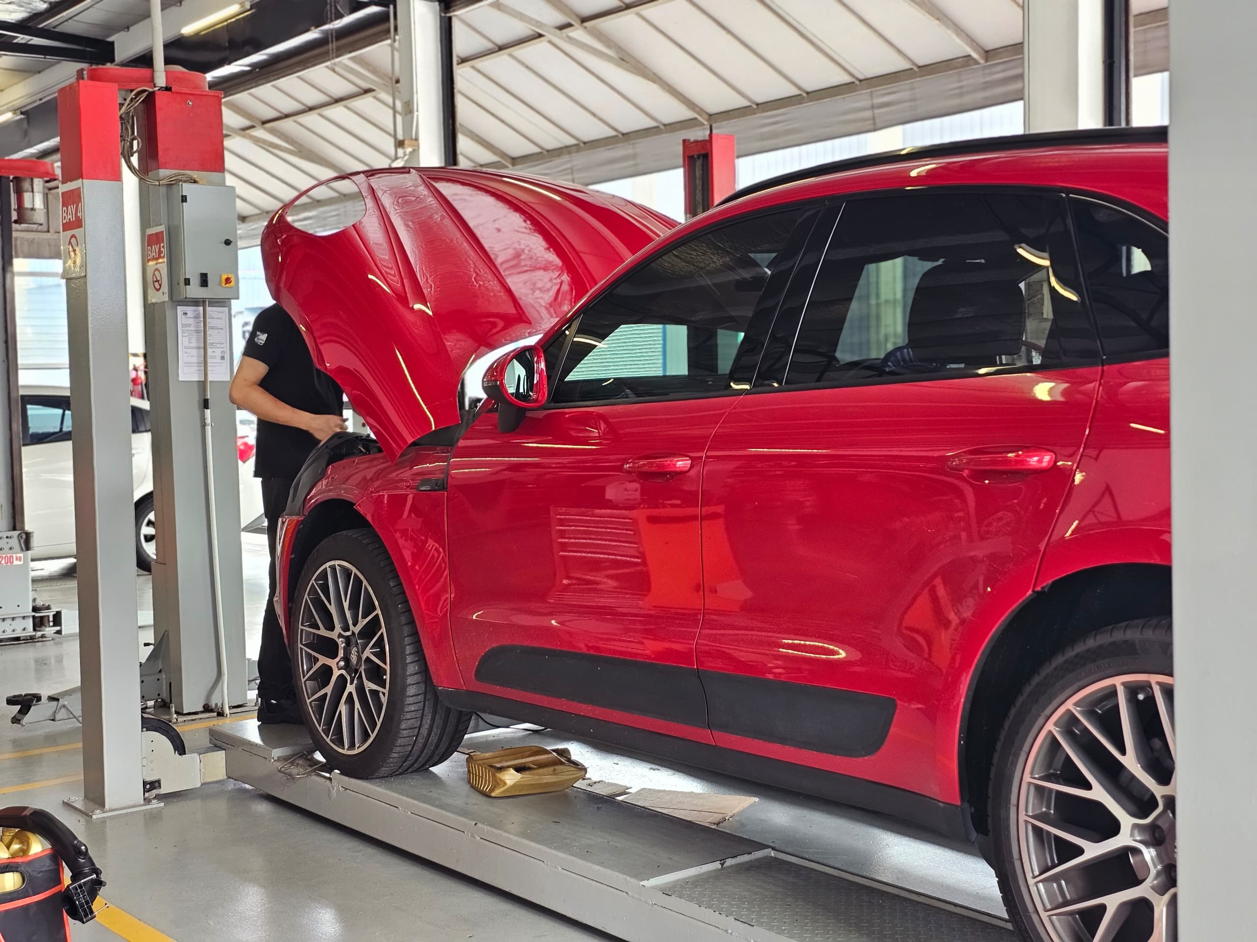 TPL worker repairing red porsche macan